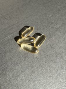 Goldfarbene Omega-3-Gelkapseln auf neutralem Hintergrund